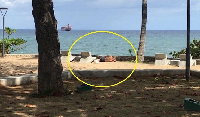 Un extranjero de apariencia asiática en el malecón con sintomas gripales