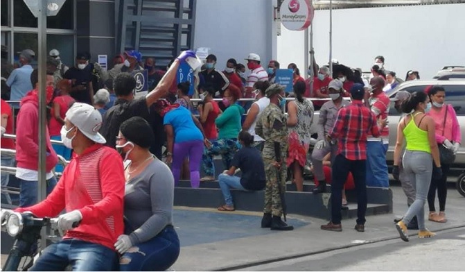 Tumulto de personas en el Banco de Reservas, en la calle Antonio de La Masa, Moca