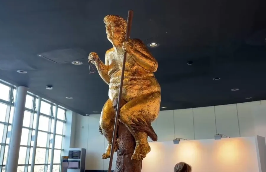 Una estatua dorada de Trump desnudo con un palo de golf sorprende al Parlamento Europeo